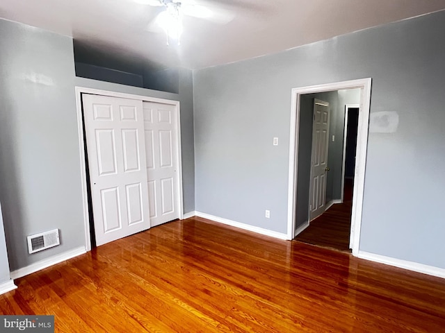 unfurnished bedroom featuring hardwood / wood-style flooring, a closet, and ceiling fan