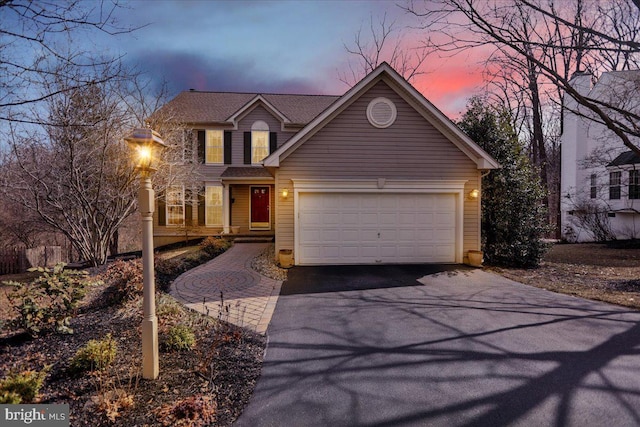 view of front of property featuring a garage and aphalt driveway