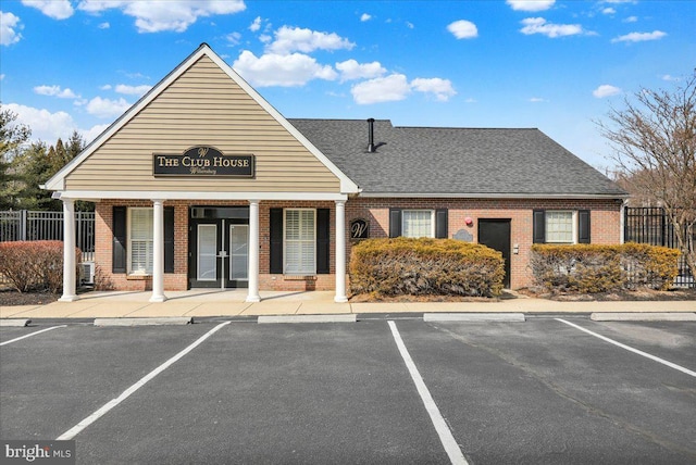 view of building exterior featuring uncovered parking and fence