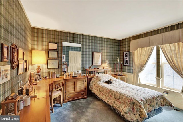 bedroom with dark colored carpet, visible vents, and wallpapered walls