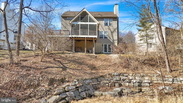 back of house with french doors, a chimney, and a sunroom