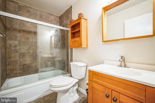 full bathroom with vanity, combined bath / shower with glass door, tile patterned floors, and toilet