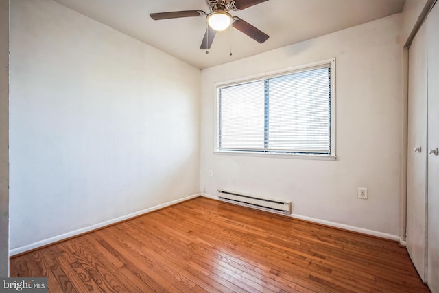 unfurnished bedroom featuring ceiling fan, a baseboard radiator, light hardwood / wood-style floors, and a closet