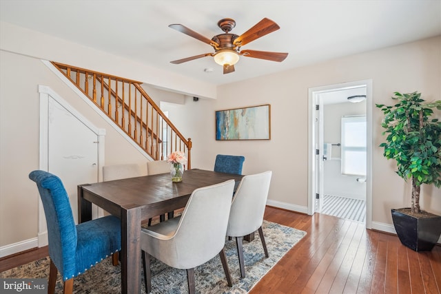 dining room featuring ceiling fan, stairway, baseboards, and dark wood finished floors