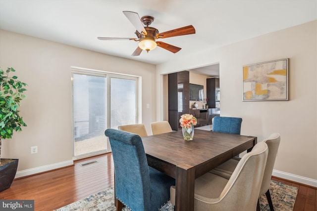 dining area featuring visible vents, baseboards, ceiling fan, and hardwood / wood-style flooring