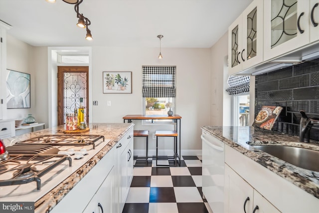 kitchen with decorative backsplash, a sink, white appliances, dark floors, and glass insert cabinets