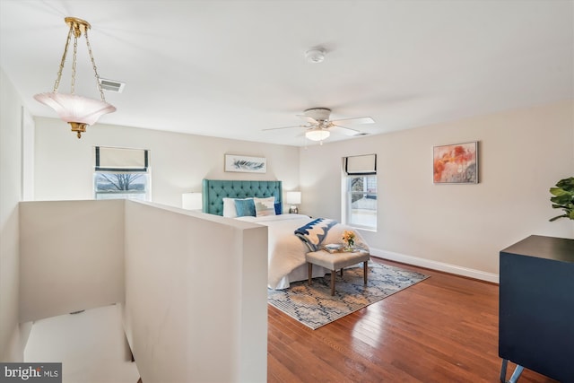 interior space featuring ceiling fan, wood finished floors, visible vents, and baseboards