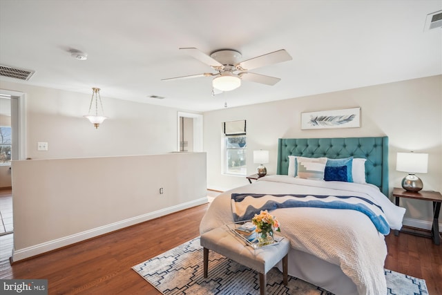 bedroom with visible vents, multiple windows, and wood finished floors