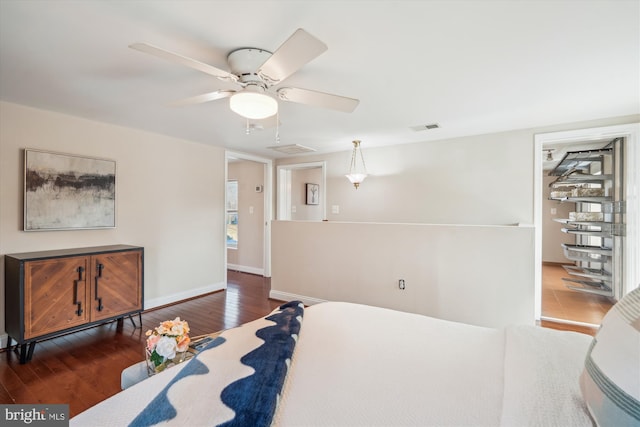 bedroom featuring ceiling fan, visible vents, baseboards, and hardwood / wood-style floors