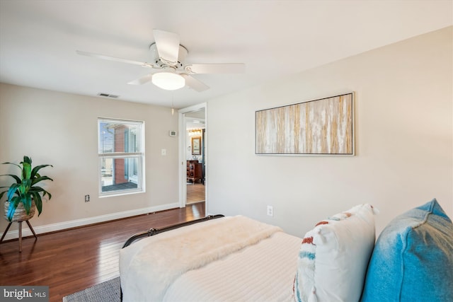 bedroom with visible vents, wood finished floors, baseboards, and ceiling fan