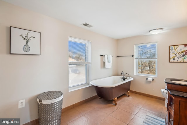 full bath with vanity, baseboards, visible vents, a soaking tub, and tile patterned floors