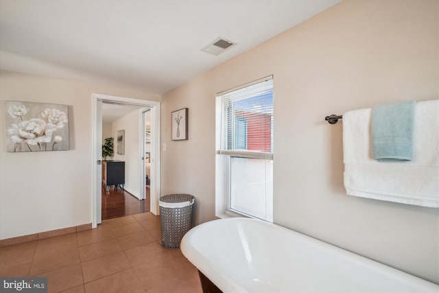 full bath with visible vents, baseboards, a soaking tub, and tile patterned flooring