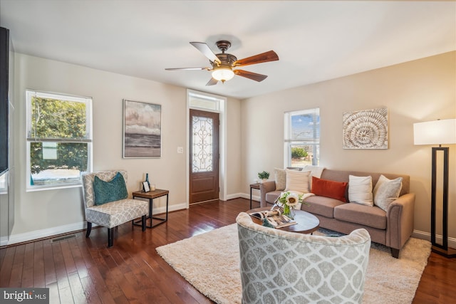 living area featuring dark wood-type flooring, visible vents, baseboards, and ceiling fan