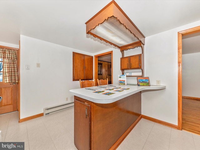 kitchen with a baseboard heating unit, kitchen peninsula, and light tile patterned flooring