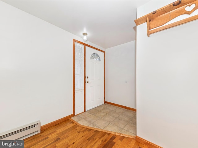 foyer entrance featuring a baseboard heating unit and light hardwood / wood-style flooring