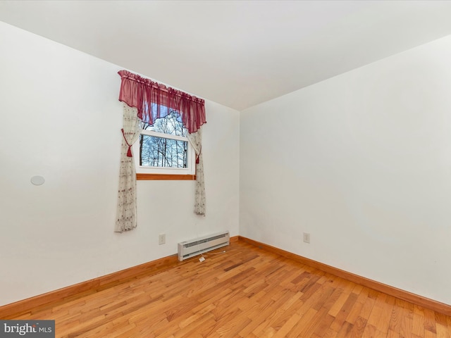 spare room with hardwood / wood-style floors and baseboard heating