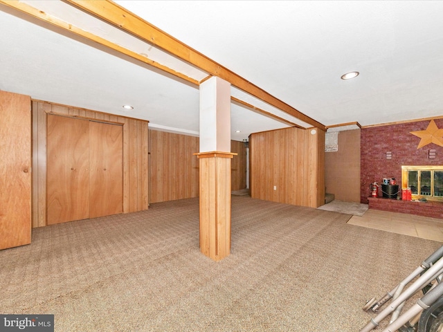 basement featuring light carpet and wooden walls