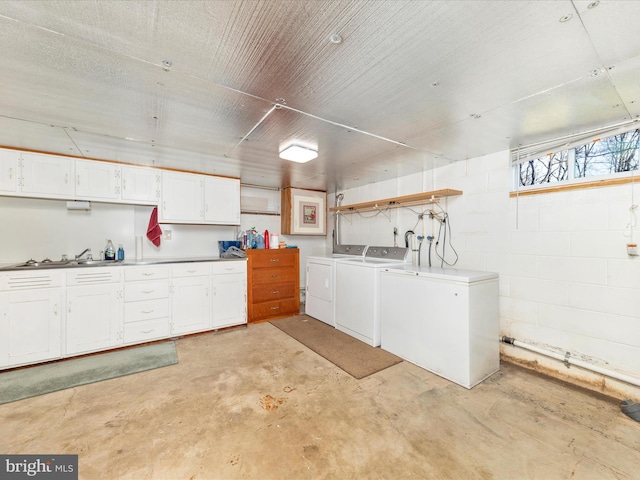 washroom with cabinets, sink, and washer and dryer