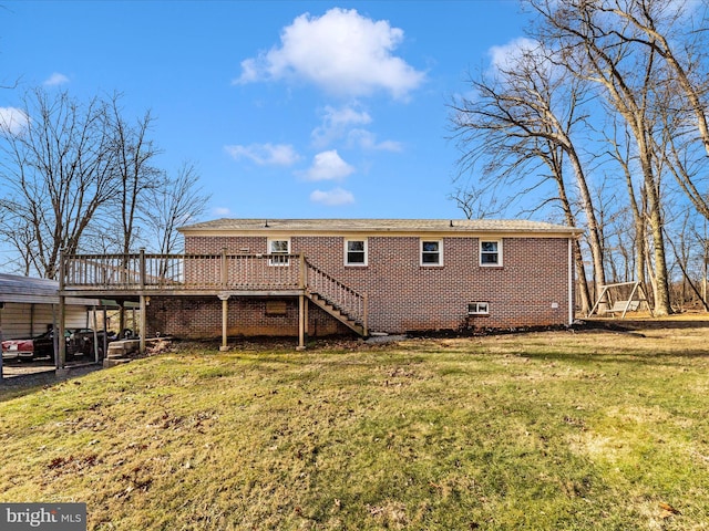 rear view of property featuring a lawn, a carport, and a deck