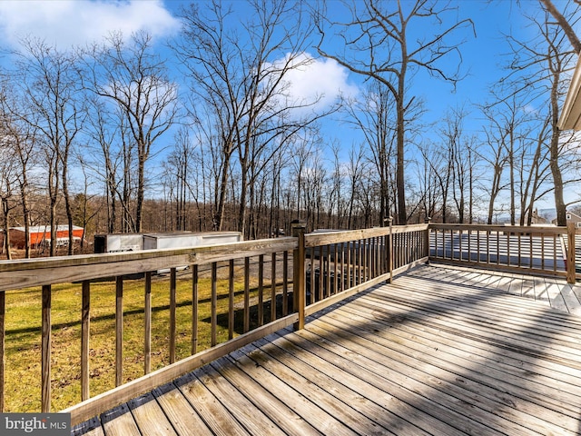 wooden deck featuring a lawn