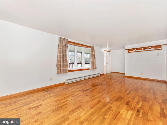 spare room with light wood-type flooring and baseboard heating