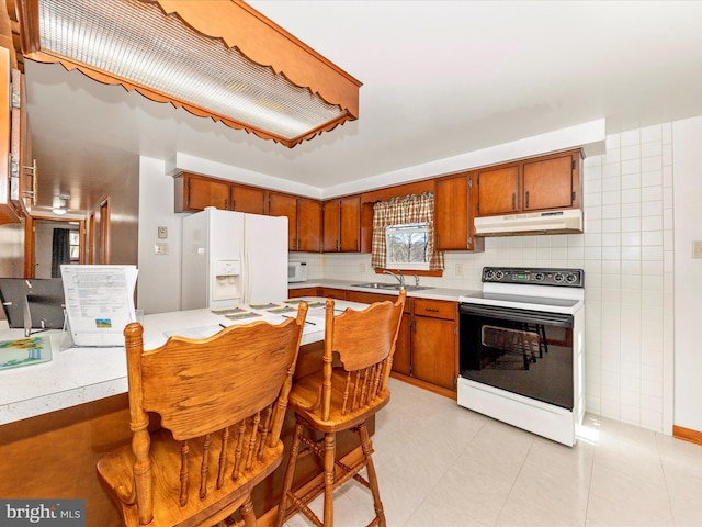 kitchen with sink, electric range oven, light tile patterned floors, white fridge with ice dispenser, and decorative backsplash