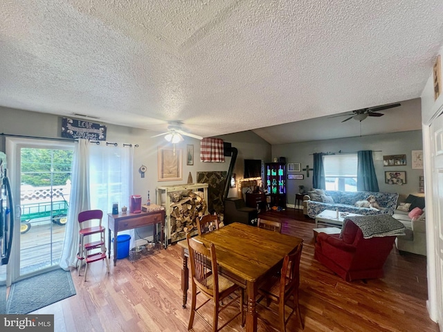 dining area with hardwood / wood-style flooring, a healthy amount of sunlight, and a wood stove