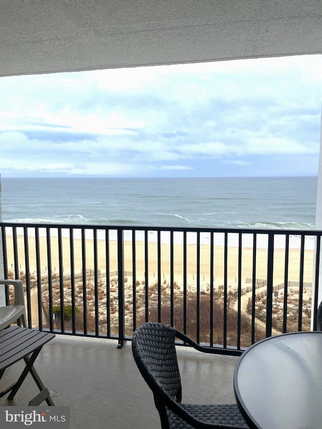 balcony featuring a water view and a view of the beach