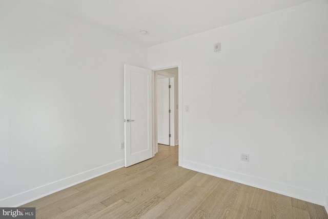 spare room featuring light wood-type flooring and baseboards