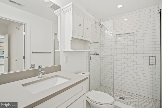 bathroom featuring a stall shower, visible vents, and toilet