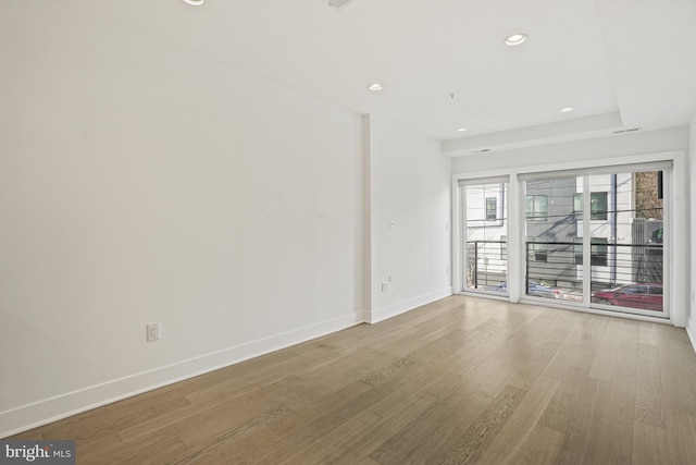 unfurnished room with recessed lighting, wood finished floors, and baseboards