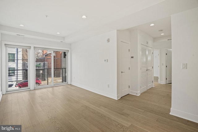 spare room featuring recessed lighting, baseboards, and wood finished floors