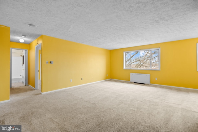 unfurnished room featuring light carpet and a textured ceiling