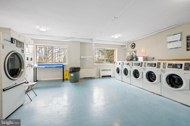 clothes washing area featuring radiator heating unit and washing machine and clothes dryer