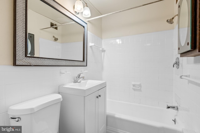 full bathroom with tiled shower / bath combo, vanity, tile walls, and toilet