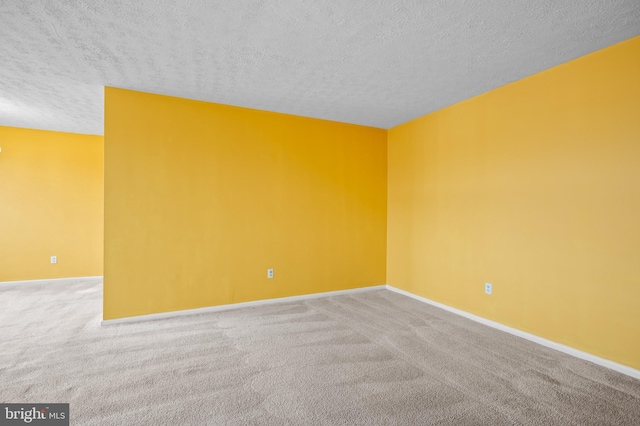 carpeted spare room with a textured ceiling