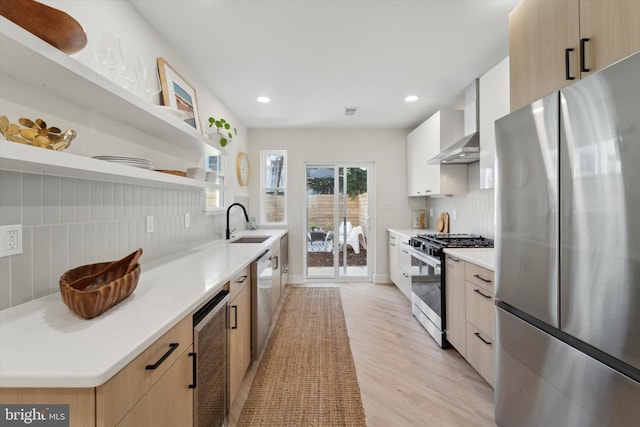 kitchen with wine cooler, sink, wall chimney range hood, stainless steel appliances, and backsplash