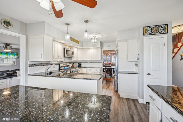 kitchen with pendant lighting, sink, dark wood-type flooring, appliances with stainless steel finishes, and white cabinetry