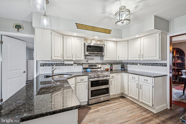 kitchen with pendant lighting, stainless steel appliances, and white cabinets