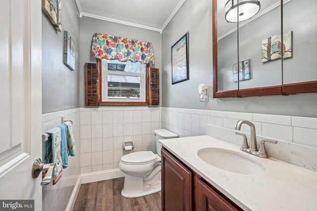 bathroom featuring toilet, tile walls, ornamental molding, vanity, and hardwood / wood-style flooring