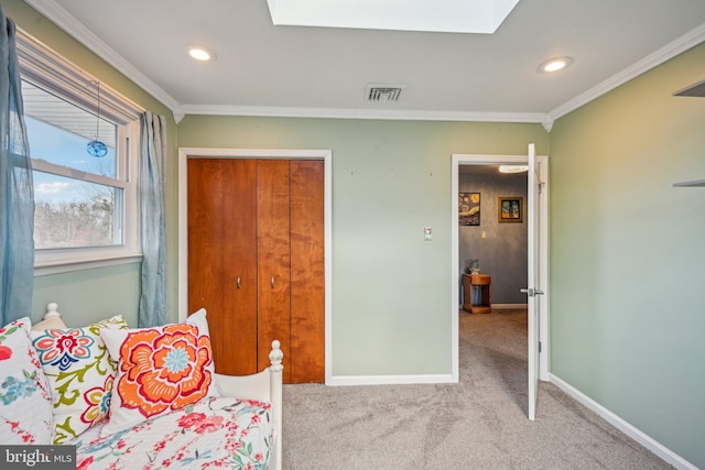 carpeted bedroom with a skylight and ornamental molding