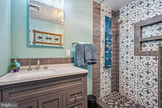 bathroom featuring vanity and tiled shower