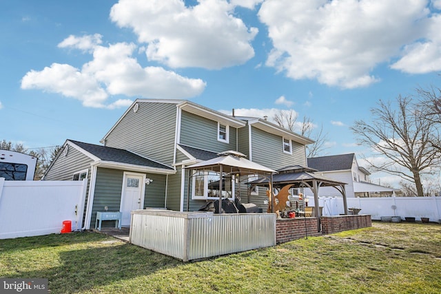 rear view of property featuring a gazebo and a yard