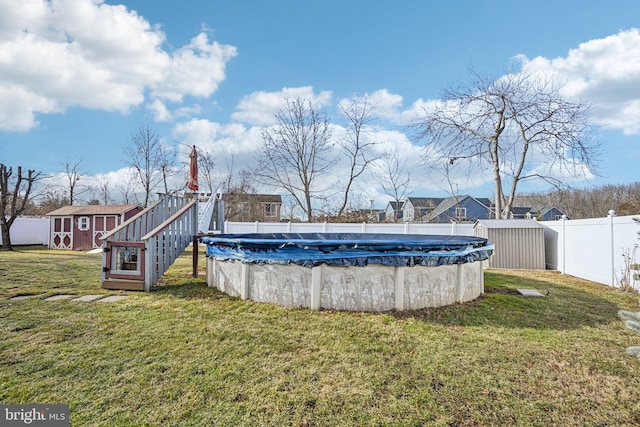 view of yard with a covered pool and a storage unit