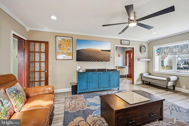 living room with crown molding, ceiling fan, and light hardwood / wood-style floors