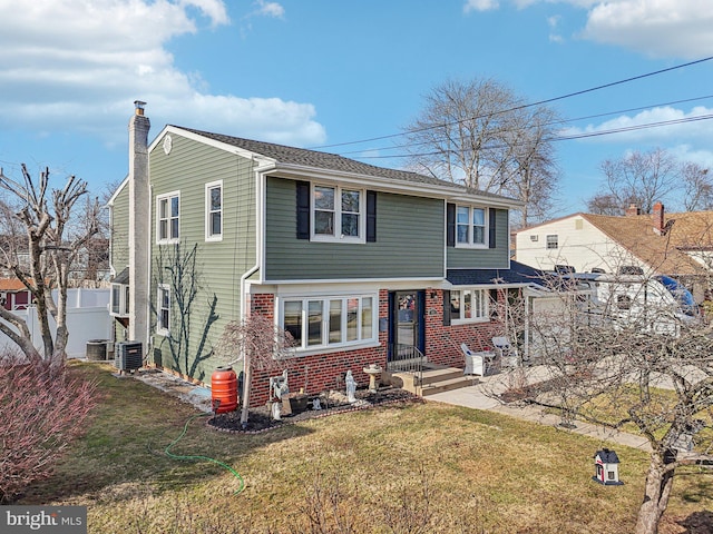 view of front facade with a front yard and cooling unit