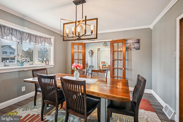 dining area with crown molding, a chandelier, and dark hardwood / wood-style flooring