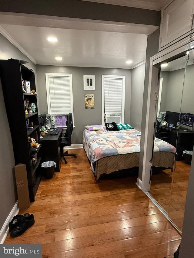 bedroom with ornamental molding and light hardwood / wood-style floors