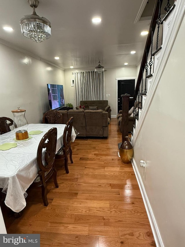 dining area with ornamental molding and light hardwood / wood-style flooring