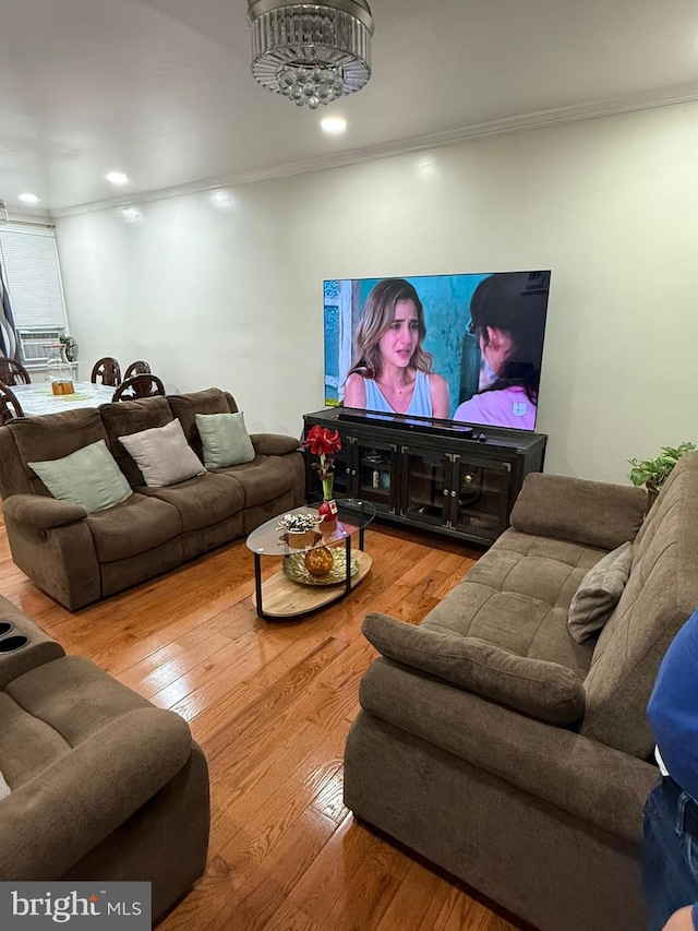 living room with wood-type flooring and crown molding